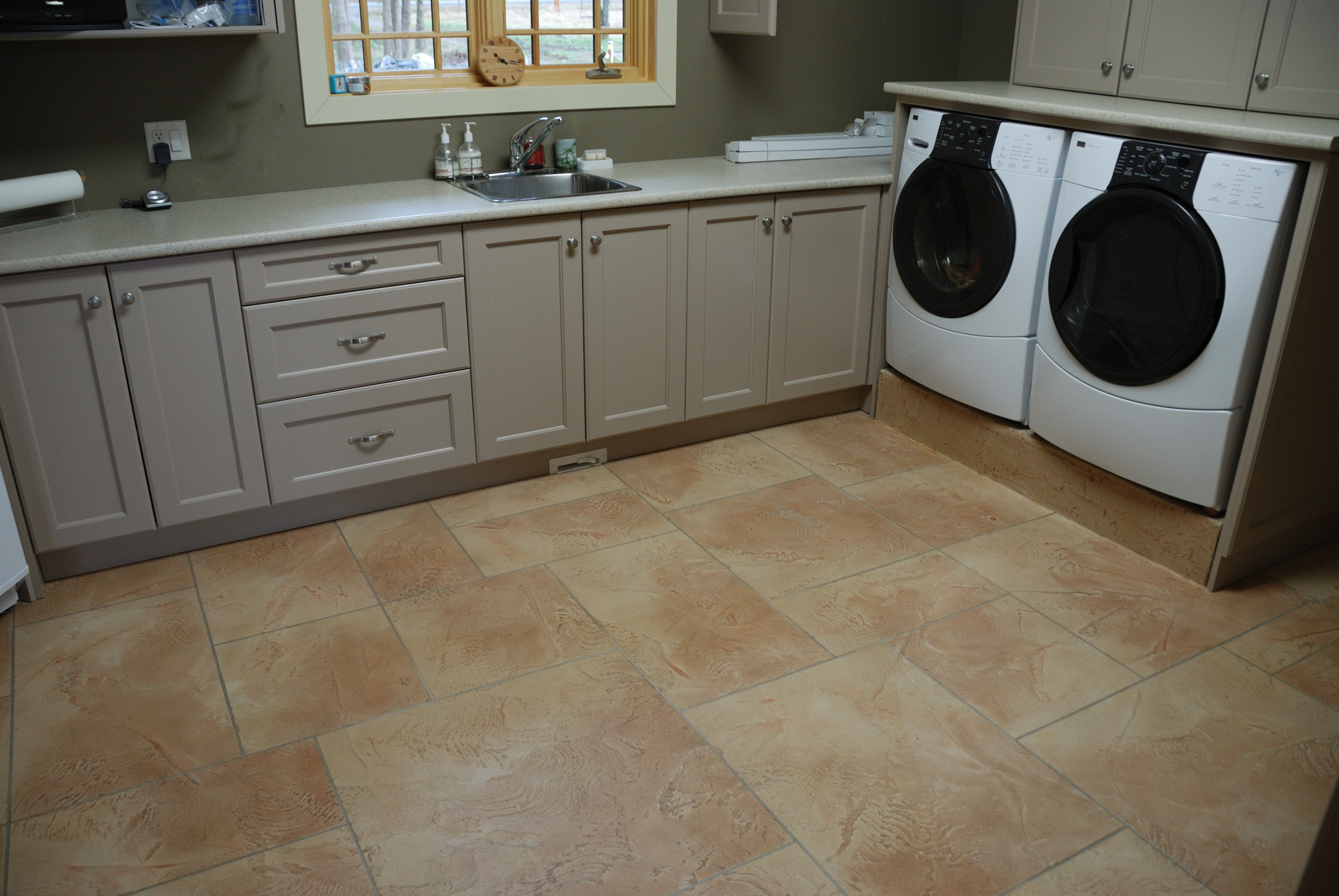 Residential laundry room with warm sandstone floor