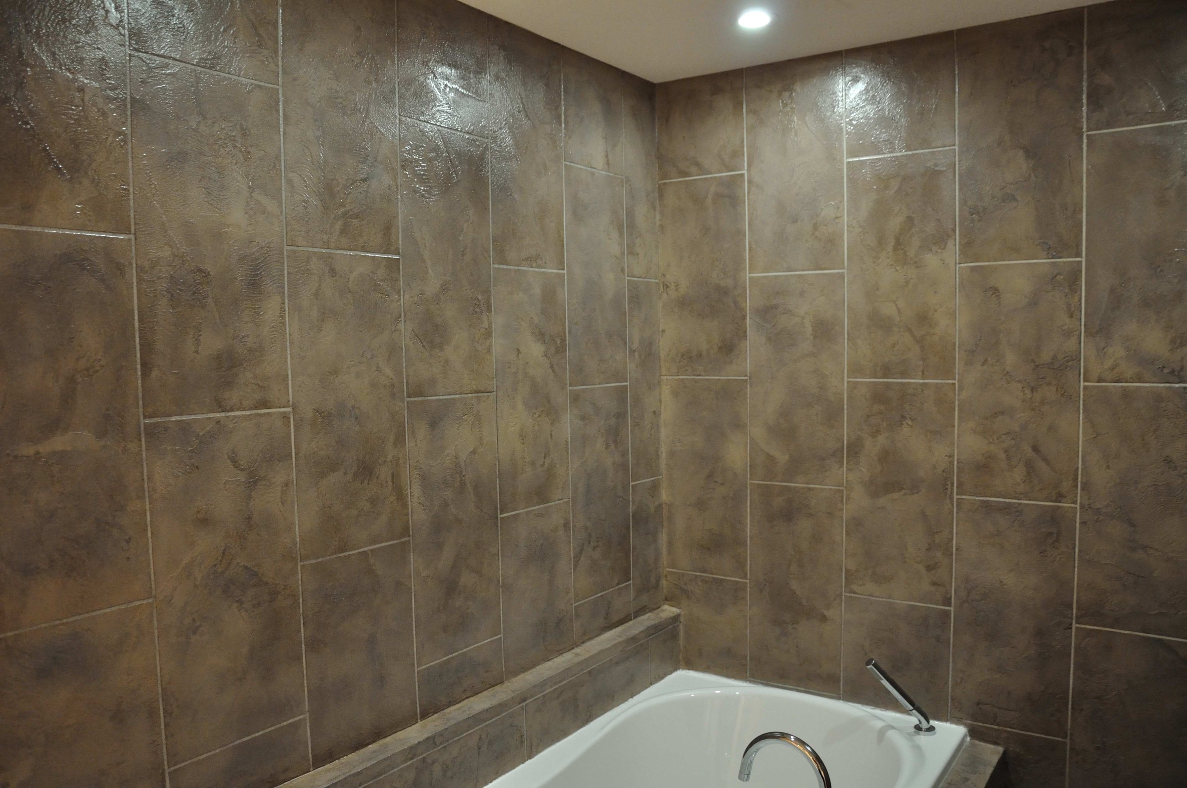Bathtub with bronze-toned StoneCraft wall surround panels