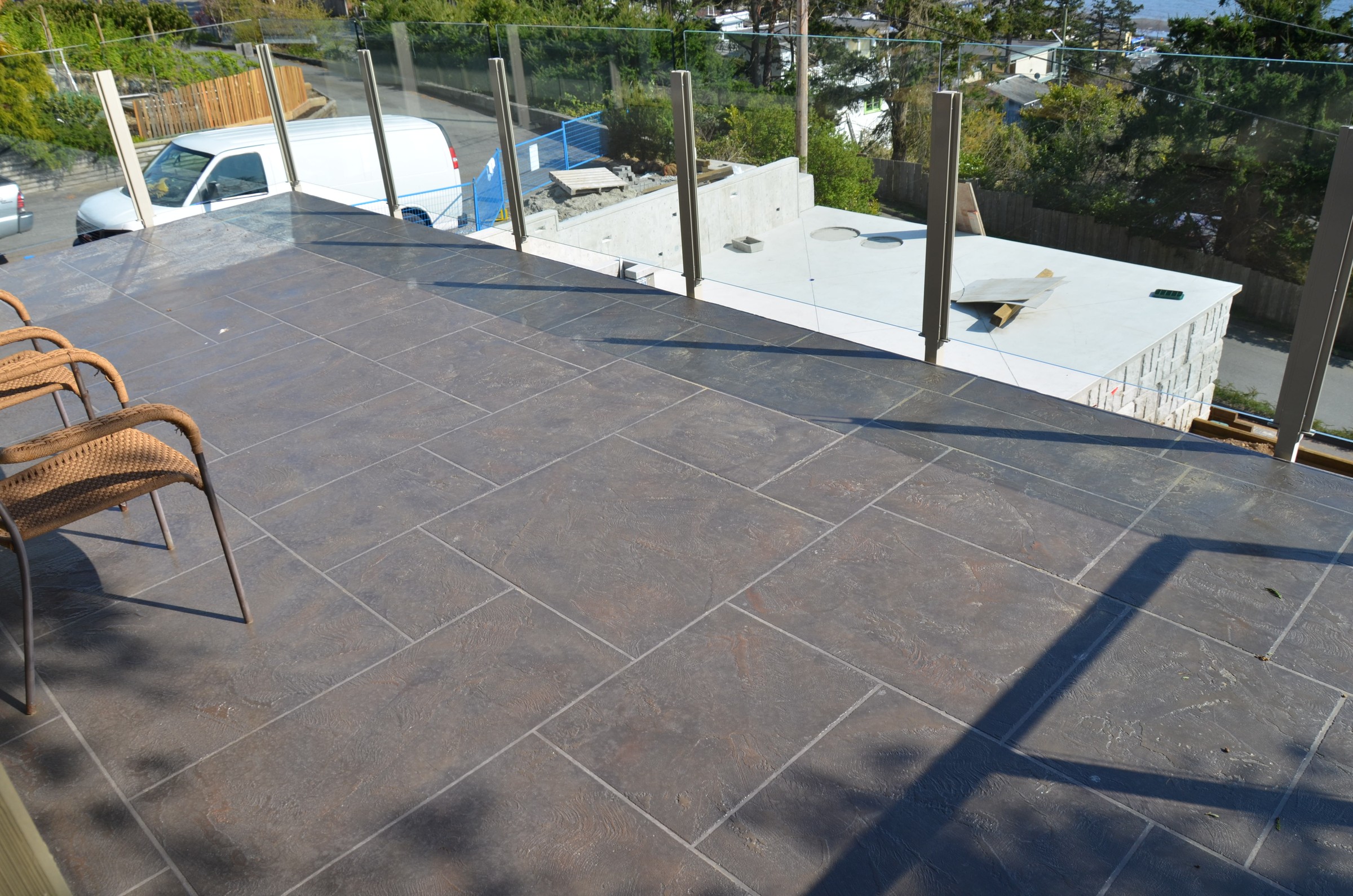Dark charcoal StoneCraft waterproofed deck with glass railing
