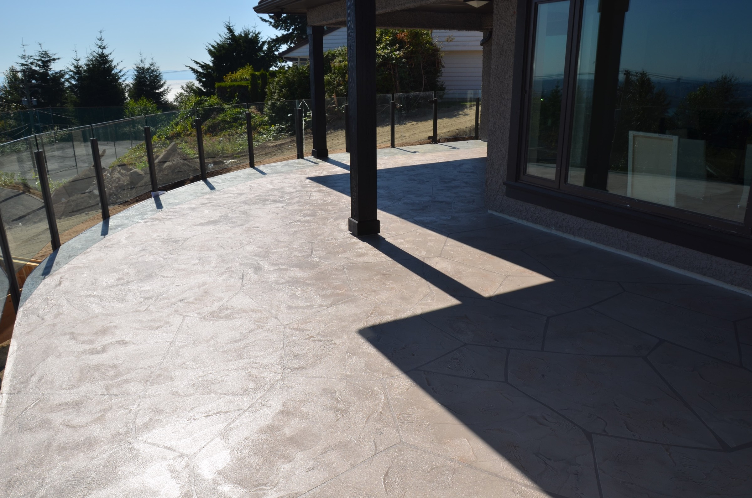 Cobblestone pattern StoneCraft curved deck with glass railings