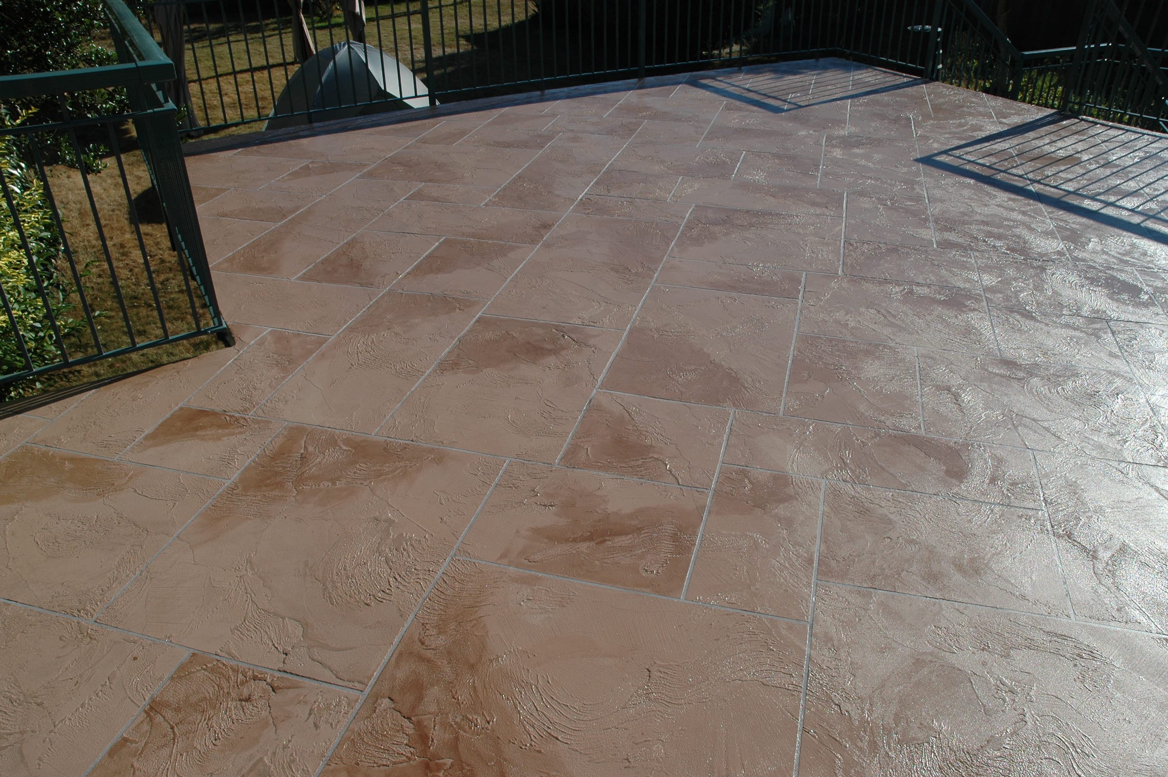 Warm sandstone-toned waterproofed StoneCraft deck with decorative tile pattern