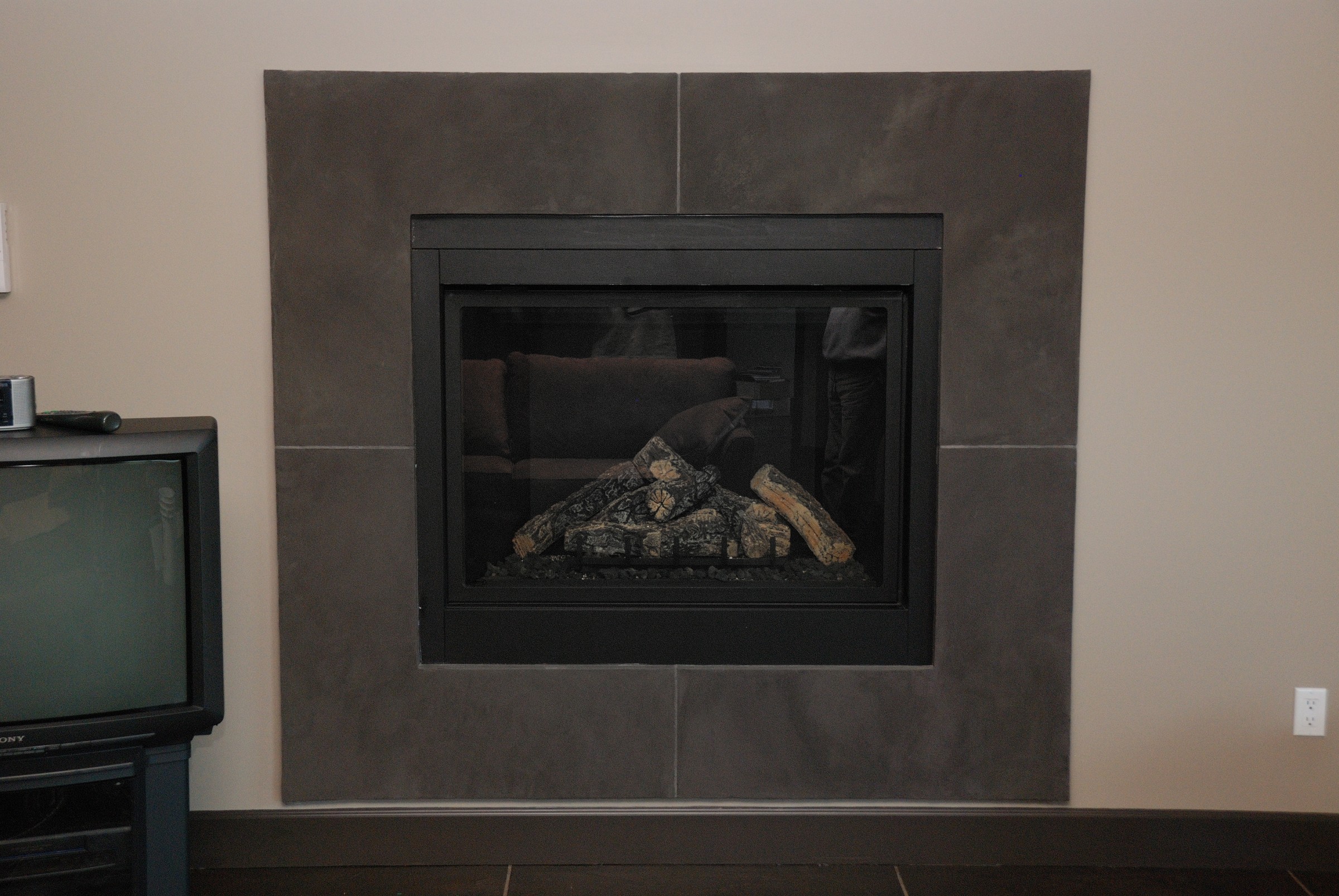 Modern charcoal StoneCraft fireplace surround with clean lines