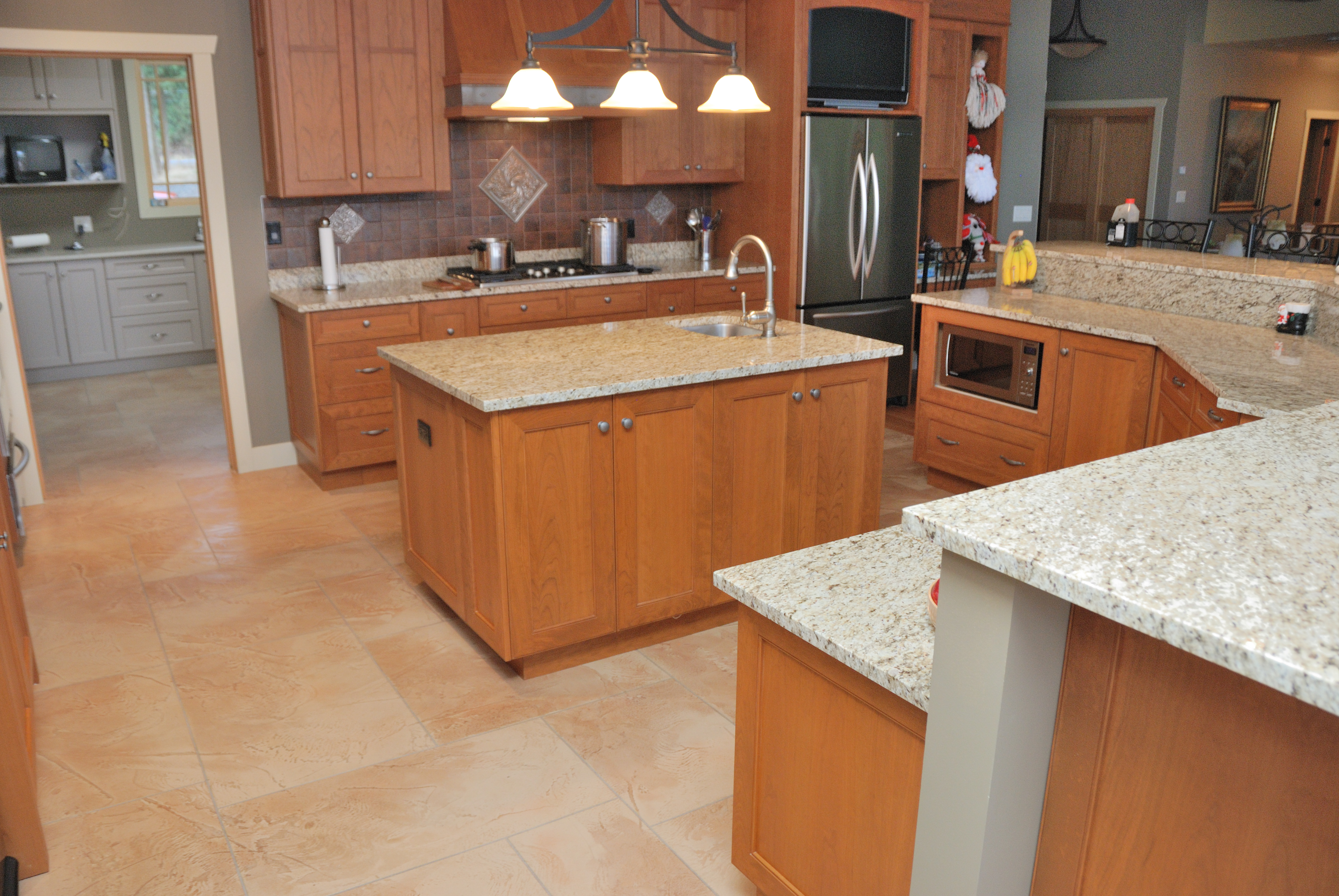 Open kitchen with warm sandstone StoneCraft flooring and centre island