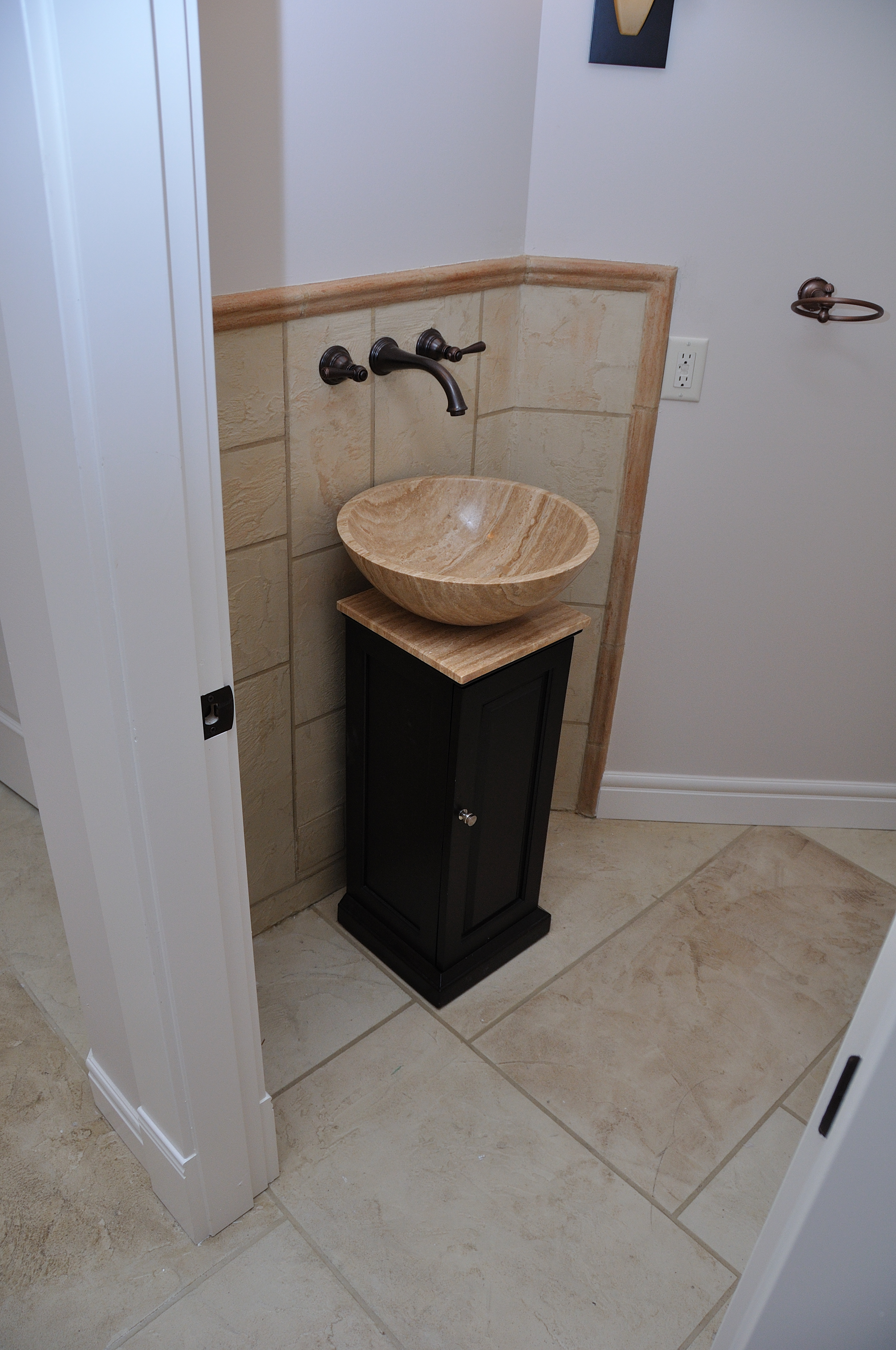 Powder room with cream StoneCraft flooring and vessel sink backsplash