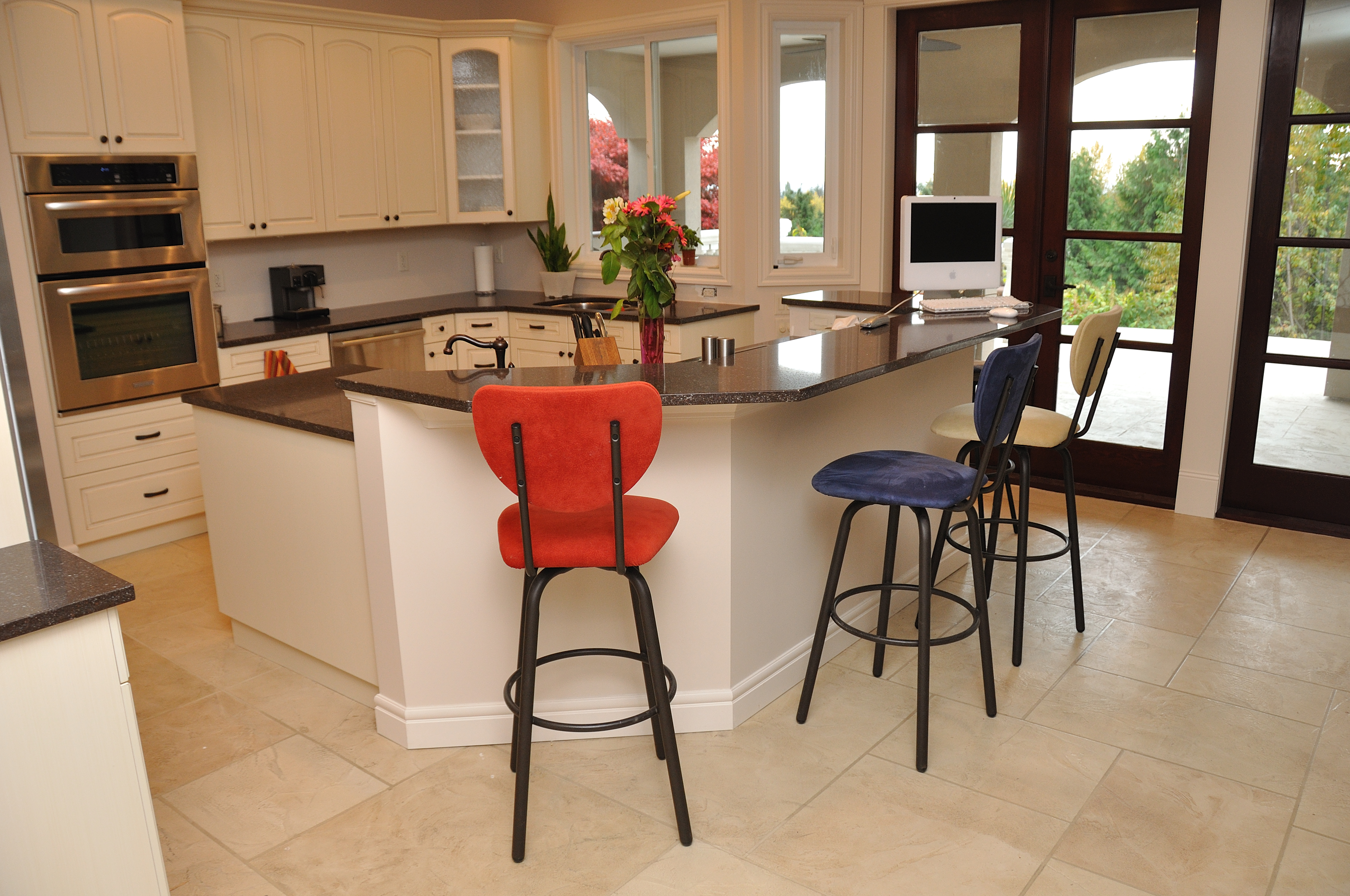 Bright kitchen with cream StoneCraft flooring and island bar seating