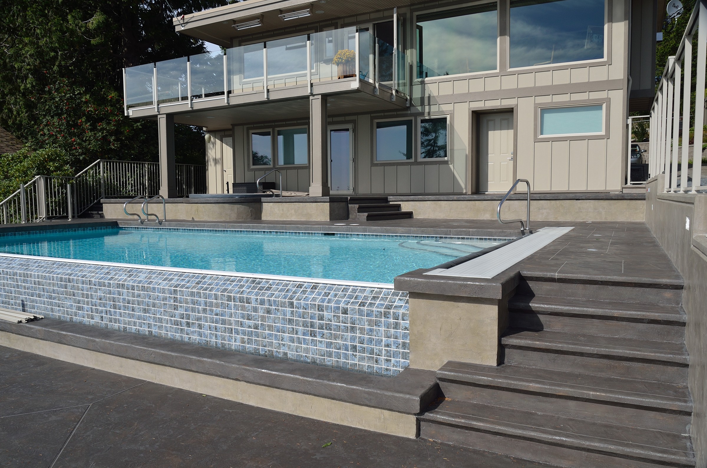 Modern elevated pool with dark StoneCraft decking and multi-level design