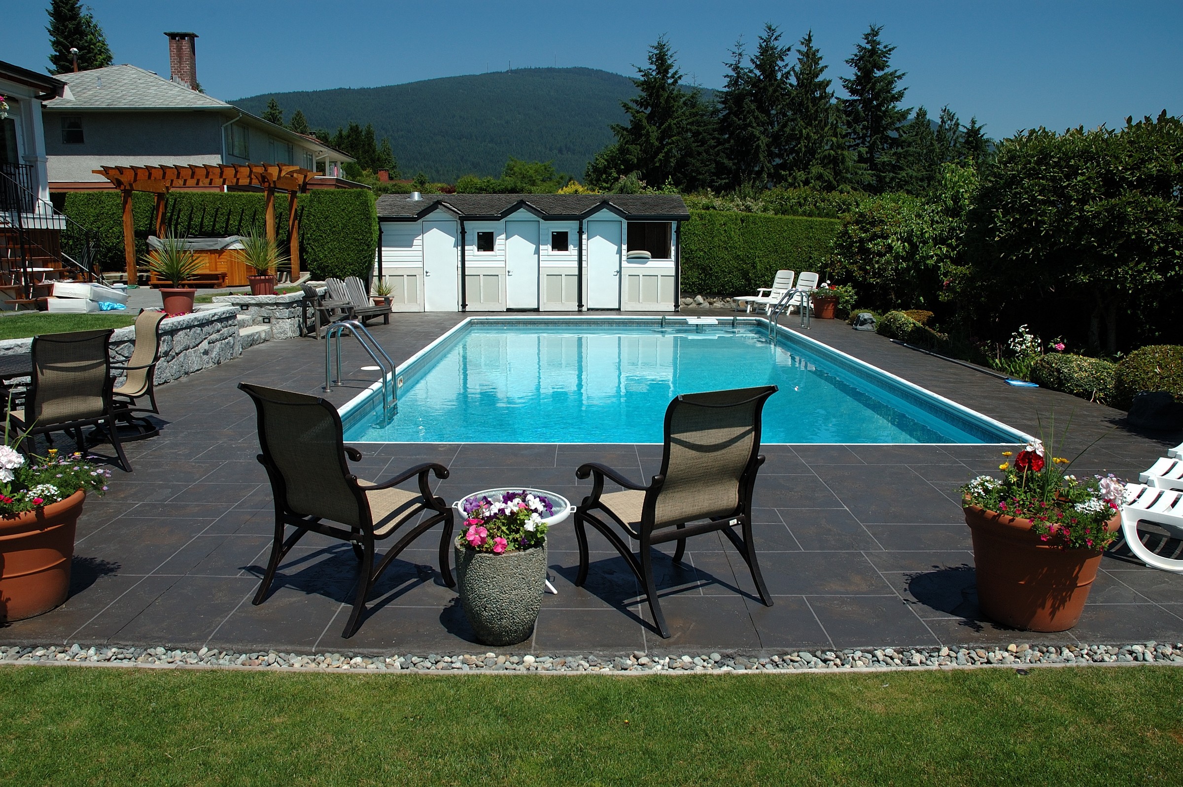 Pool with dark charcoal StoneCraft decking and mountain backdrop